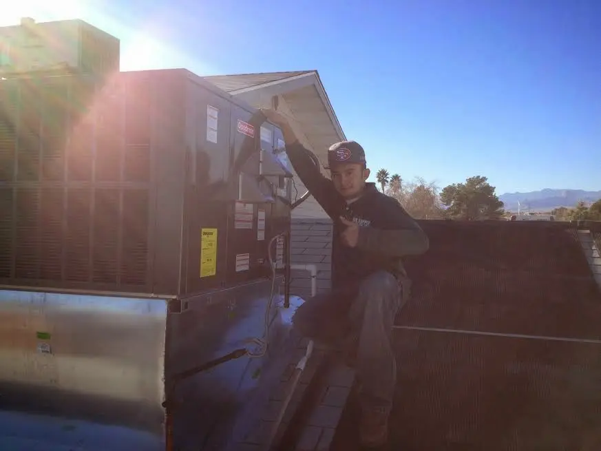 HVAC technician performing Boiler Repair on a rooftop unit in Hillsdale